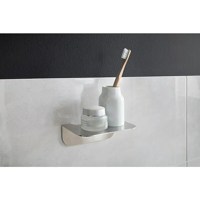Camargue Antwerpen Ablage - Breite: 15 cm, Edelstahl, Matt - Dieses Bild zeigt ein modernes Badregal mit einer Creme, einem Zahnputzbecher und einer Zahnbürste vor einem eleganten Hintergrund.