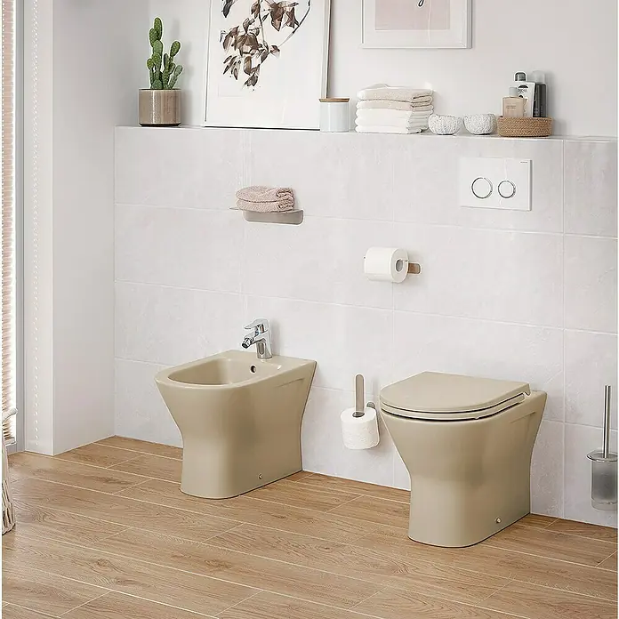 RAK Ceramics Feeling Stand-WC - Spülrandlos, Ohne Spezialglasur, Spülform: Tief, WC Abgang: Waagerecht, Cappuccino - Eine moderne Toilette und ein Bidet in einem stilvollen Badezimmer, das ein elegantes und komfortables Design präsentiert.