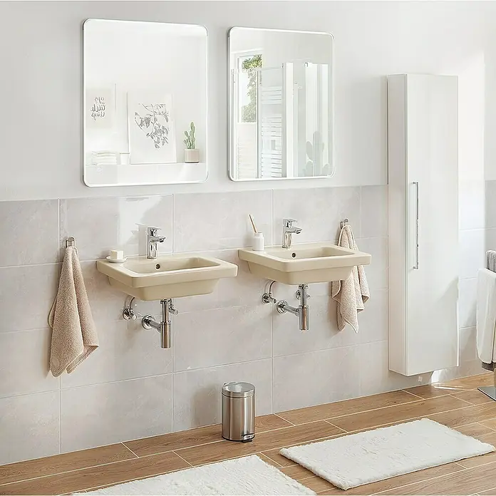 RAK Ceramics Feeling Waschtisch - 55 x 46 cm, Ohne Spezialglasur, Hahnloch: Mitte, Mit Überlauf, Greige, Matt - Badezimmer mit zwei eckigen Waschtischen in Beige, die unter zwei Spiegeln hängen, und einem weißen Hochschrank.