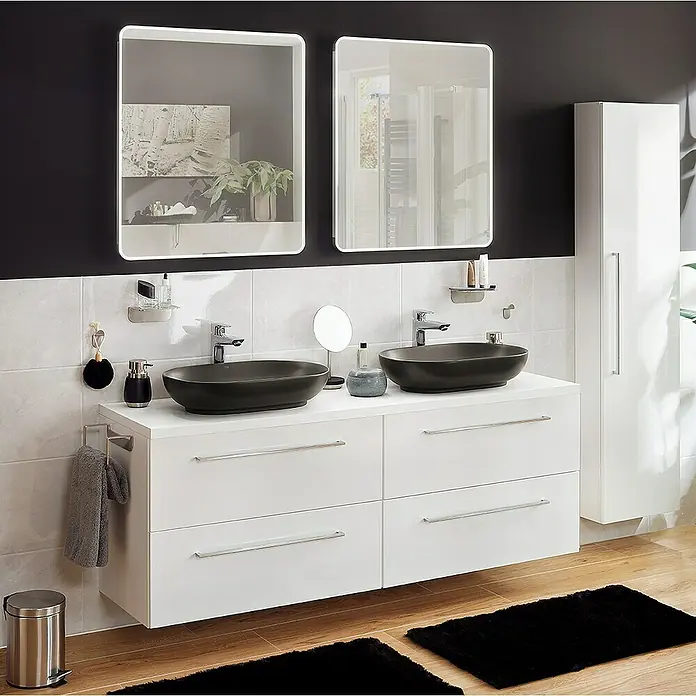 RAK Ceramics Feeling Aufsatzwaschbecken - 55 x 35 cm, Ohne Spezialglasur, Hahnloch: Ohne, Ohne Überlauf, Schwarz, Matt - Ein modernes Badezimmer mit Doppelwaschbecken, weißen Schränken und zwei beleuchteten Spiegeln vor einer dunklen Wand.