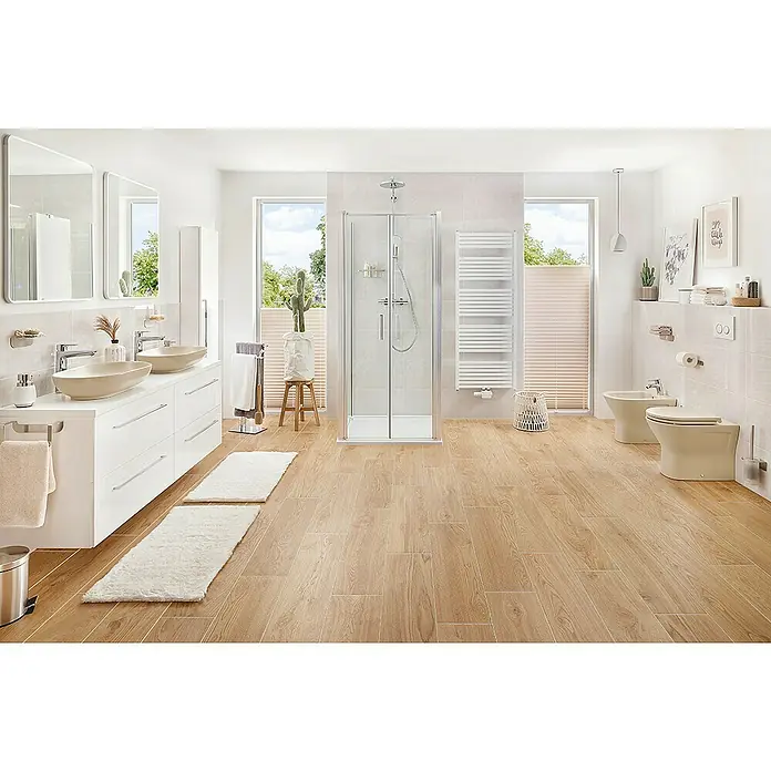 RAK Ceramics Feeling Stand-WCSpülrandlos, Ohne Spezialglasur, Spülform: Tief, WC Abgang: Waagerecht, Greige - Ein helles Badezimmer mit zwei Waschbecken, einer Dusche, einem beheizten Handtuchhalter und einer Toilette mit Bidet in beige Farbe.