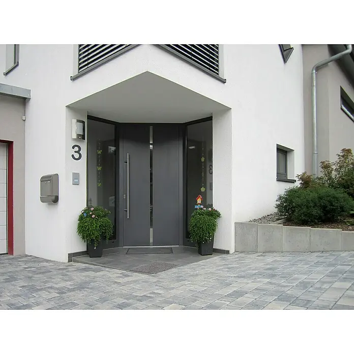 Diephaus L-SteinUnbewehrt, Höhe: 60 cm, Breite: 50 cm, Stärke: 7 cm, Grau - Die moderne Haustür mit Glaselementen und der Hausnummer 3 präsentiert sich einladend, flankiert von grünen Pflanzenarrangements in dunklen Pflanzgefäßen.