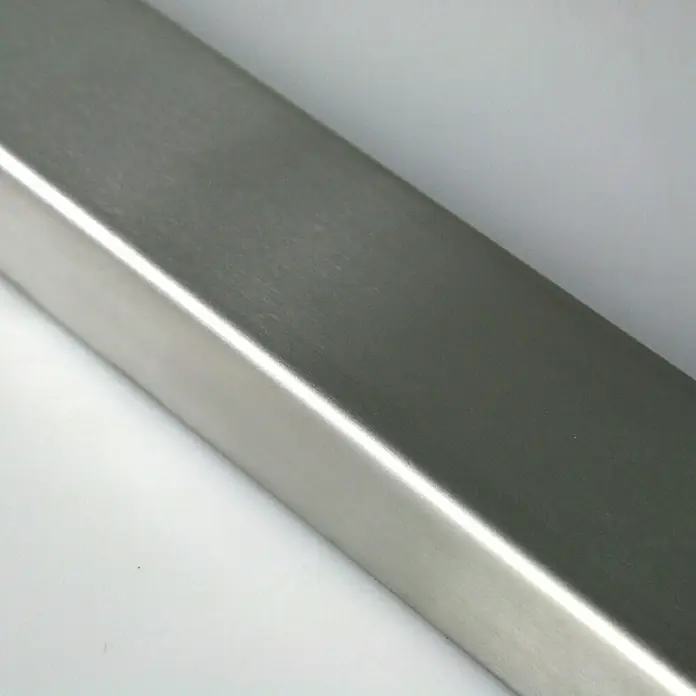 Fuchs Design Glasbausteinprofil - Edelstahl, Gebürstet, 200 x 5,6 x 2,5 cm - Nahaufnahme eines glänzenden Vierkantrohrs aus Edelstahl. Es zeigt seine glatte Oberfläche und präzisen Kanten in einer hellen Umgebung.