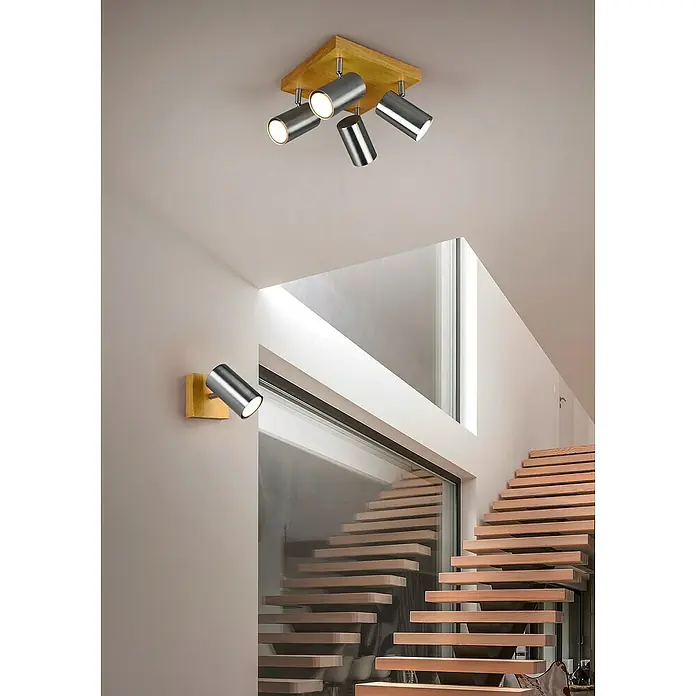 Trio Lighting Marley Regleta - 60 W, L x An x Al: 22 x 22 x 16 cm, Marrón, GU10, 4 ud. - Vista interior moderna con una escalera de madera y focos en el techo y la pared. Las lámparas son de metal y emiten luz brillante.