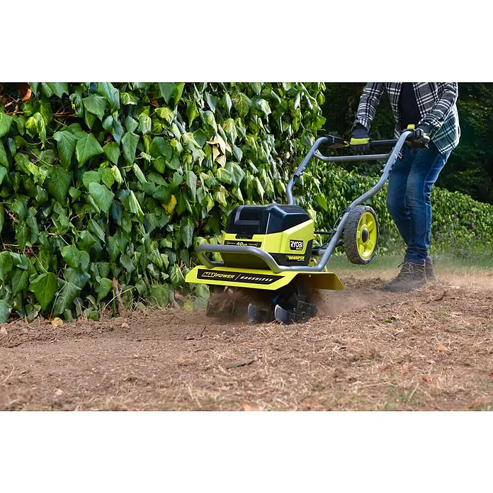 Ryobi Max Power Akku-Bodenhacke RY36CVXA-0 - Anzahl Akkus: Ohne Akku, Li-Ionen - Nahaufnahme eines Ryobi Akku-Bodenhackers, der im Garten zur Bodenbearbeitung eingesetzt wird.\n