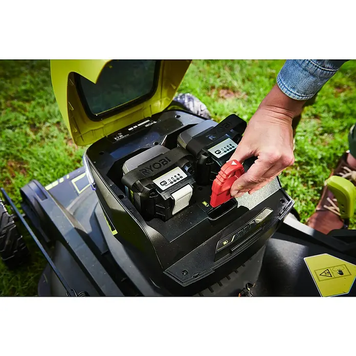 Ryobi Max Power Akku-Rasenmäher RY36LMXSP53A-160 - 36 V, 1 Akku, 6 Ah, Schnittbreite: 53 cm - Ryobi Rasenmäher mit Akku-Fach offen, eine Hand setzt einen roten Sicherheitsschlüssel ein, Akkus sind sichtbar.