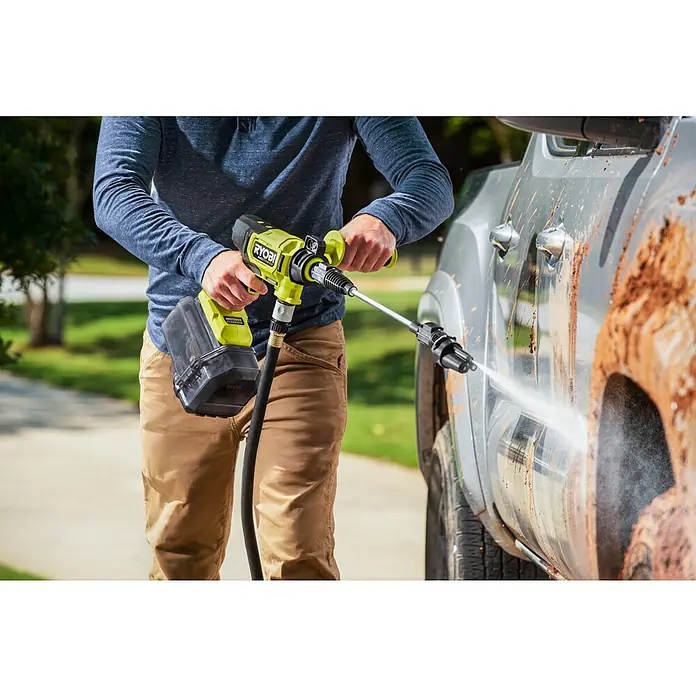 Ryobi Max Power Akku-Hochdruckreiniger RY36PWX41A-0 - 36 V, Ohne Akku, Max. Druck: 41 bar, Fördermenge: 160 l/h - Akku-betriebener Ryobi-Reiniger im Einsatz, um Schmutz von einem Fahrzeug zu entfernen, mit Akku und Schlauch gut sichtbar.
