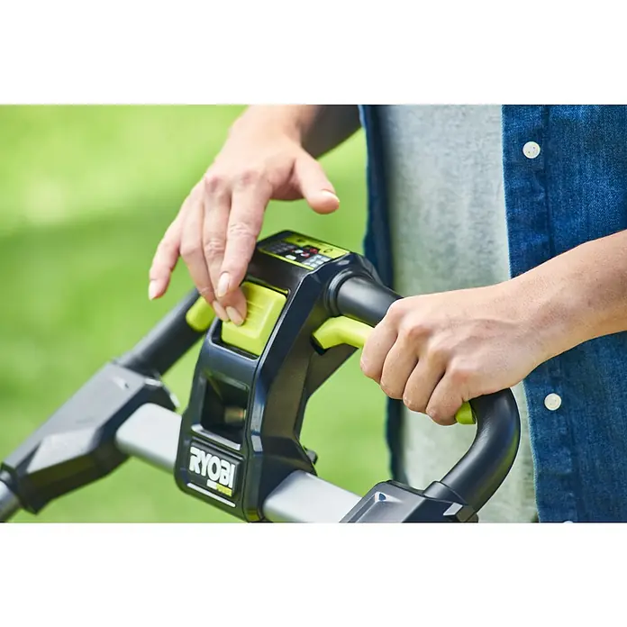 Ryobi Max Power Akku-Rasenmäher RY36LMXSP46A-150 - 36 V, 1 Akku, 5 Ah, Schnittbreite: 46 cm - Nahaufnahme der Hände einer Person, die einen Ryobi-Trimmer bedient, wobei der Fokus auf dem Griff und der grünen Taste liegt.