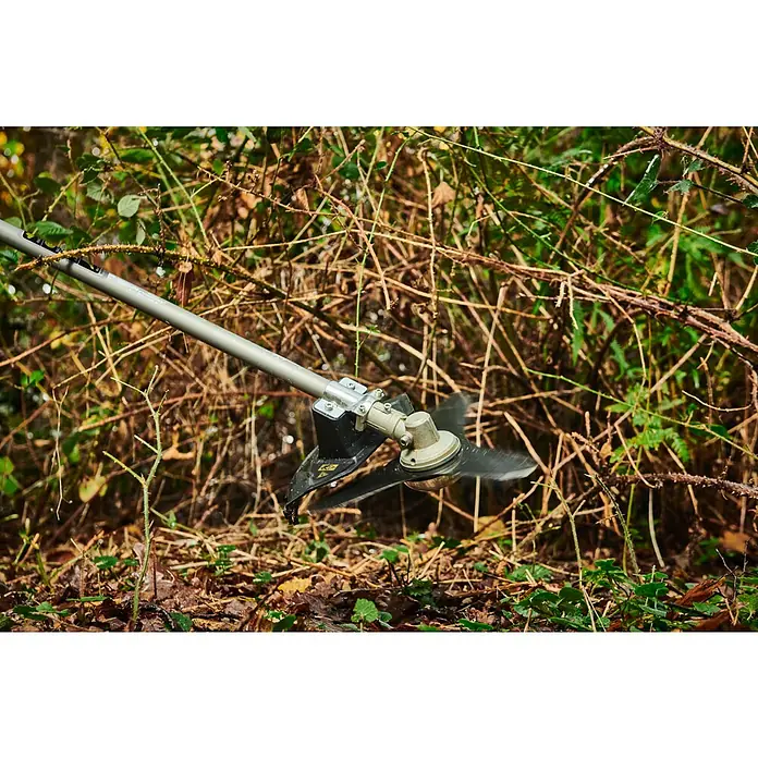 Ryobi Max Power Akku-Freischneider RY36BCX30A-9 - 36 V, Ohne Akku, Schnittbreite Faden: 40 cm, Schnittbreite Messer: 30 cm - Nahaufnahme eines Trimmers mit scharfer Klinge, der durch dichtes Gestrüpp schneidet und eine effektive Gartenarbeit demonstriert.
