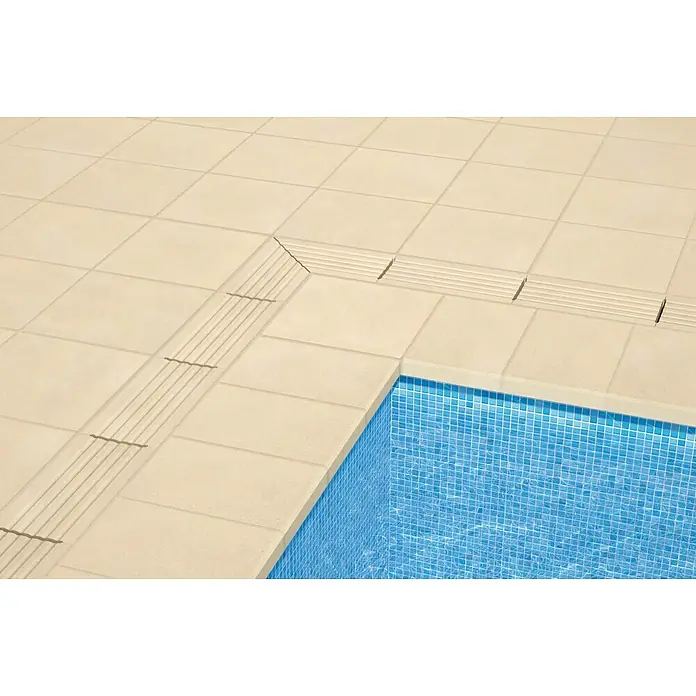 SAS Tessera Poolrandplatte - 32,8 x 50 x 6 cm, Beige, Beton - Nahaufnahme des Poolrandes mit hellbeigen Fliesen und integriertem Abfluss, der das moderne Design und die Funktionalität hervorhebt.