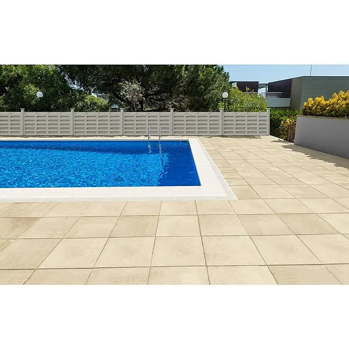 SAS Tessera Poolrandplatte - 50 x 35,5 x 6 cm, Weiß, Beton - Außenaufnahme eines Pools mit klarem, blauem Wasser und hellen Steinplatten, umgeben von einem Zaun, der Privatsphäre bietet und das Gesamtbild ergänzt.