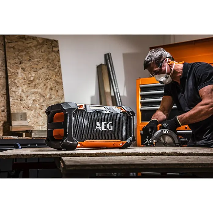 AEG Pro 18V Akku-Baustellenradio BRSP 18 - 18 V, Ohne Akku, 522 - 1.620 kHz (AM) - Werkstattradio der Marke AEG mit robustem Design und guter Klangqualität für Baustellen oder Werkstätten, während ein Handwerker arbeitet.
