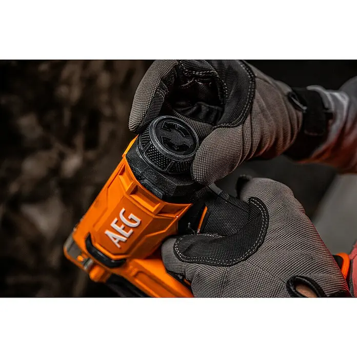AEG Pro 18V Akku-Tacker B18CS10-0 - 18 V, Ohne Akku, Klammertiefe: 6,35 mm - 14,3 mm - Nahaufnahme eines AEG-Elektrowerkzeugs, das von behandschuhten Händen gehalten wird. Fokus liegt auf dem Drehknopf zur Einstellung.