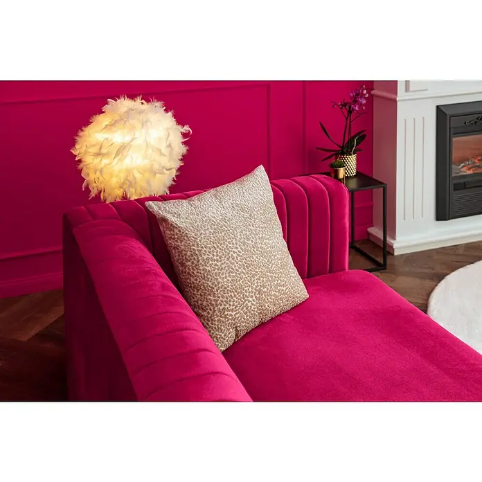 Kissen Jutta - Semolina, 45 x 45 cm, 100 % Polyester - Nahaufnahme einer pinkfarbenen Chaiselongue mit einem gemusterten Kissen, einer Federlampe und einem dekorativen Kamin.