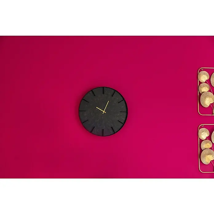 Wanduhr Anras - Durchmesser: 50 cm, Schwarz/Gold - Eine Nahaufnahme einer schwarzen Wanduhr mit goldenen Zeigern an einer pinkfarbenen Wand mit dekorativen goldenen Blättern.