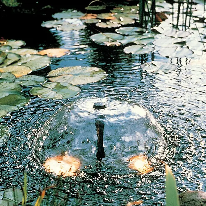 Ubbink Wasserspielpumpe Elimax 2000 - 35 W, Max. Förderhöhe: 220 cm - Gartenteich mit einer dekorativen Springbrunnen-Kuppel, die das Wasser sprudeln lässt, umgeben von Seerosenblättern für eine idyllische Atmosphäre.