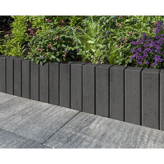 Diephaus Palisade / Mauerstein Laredo Meso - 80 x 10 x 10 cm, Basalt, Beton - Nahaufnahme einer grauen Gartenmauer, die ein Blumenbeet umrandet und so einen stilvollen Akzent im Garten setzt.