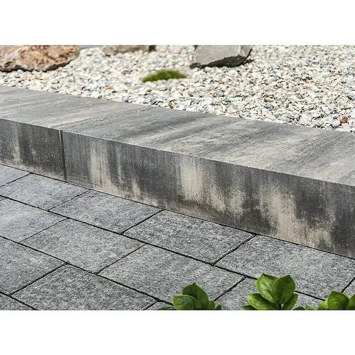 Diephaus Blockstufe Visalia - Quarzit, 100 x 35 x 15 cm, Beton - Detailaufnahme von grauen Pflastersteinen und einer Steinmauer, die eine stilvolle Gartengestaltung zeigen.\n