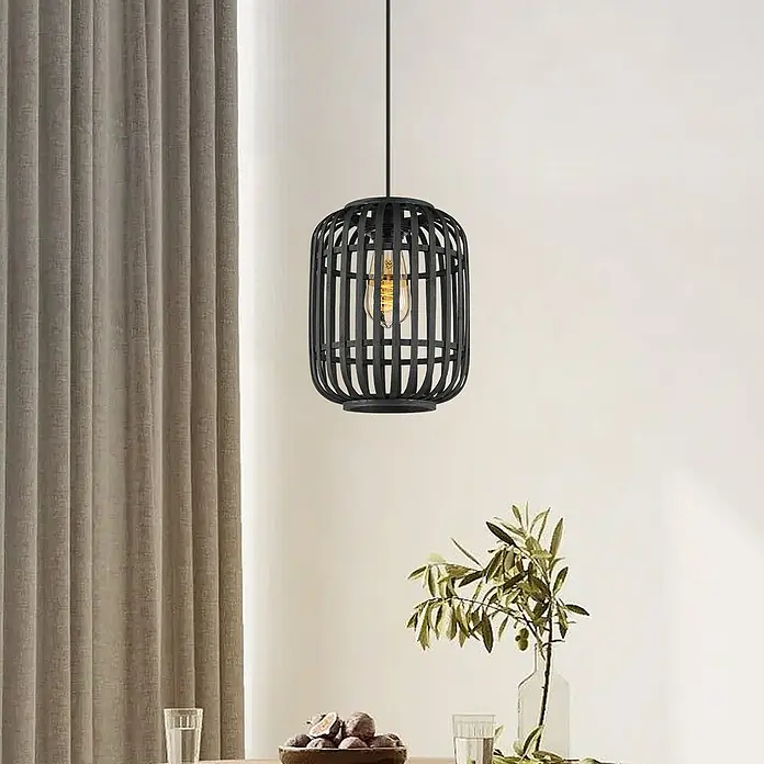 Home Sweet Home Bamboo Pendelleuchte - 10 W, L x B x H: 21,5 x 21,5 x 131 cm, Schwarz, E27 - Diese Aufnahme zeigt eine schwarze Laternen-Hängeleuchte mit einer Edison-Glühbirne, die über einem Esstisch hängt.
