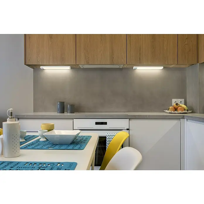 Ledvance Smart+ LED-Unterbauleuchte Slim Sensor - Länge: 30,5 cm, Mehrfarbig - Kücheninterieur mit Fokus auf moderne Holzschränke, integrierter Beleuchtung und stilvoller Arbeitsfläche mit Dekorationsgegenständen.