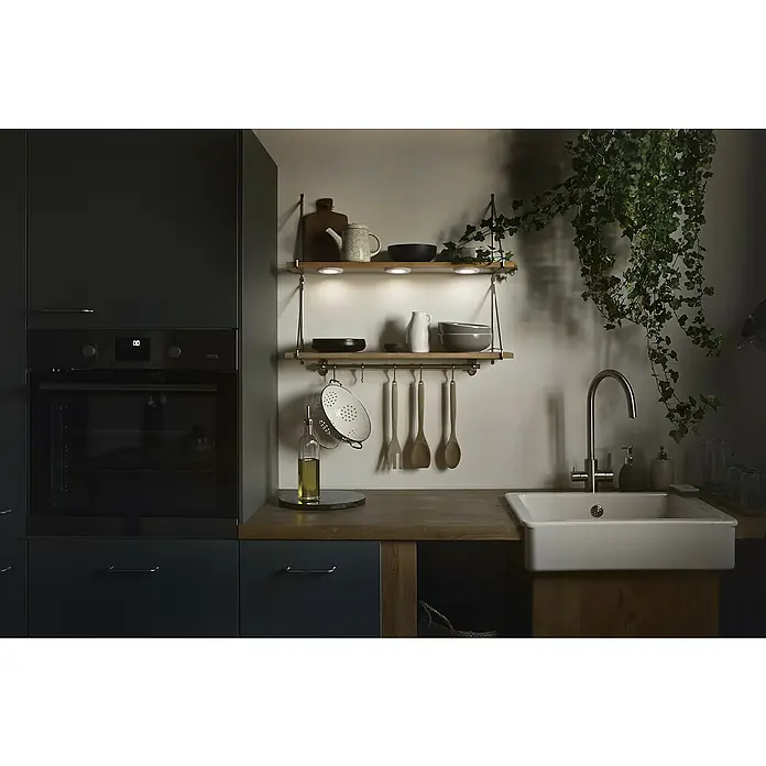 Ledvance LED-Unterbauleuchten-Set Spot Magnet - Warmweiß - Detailaufnahme einer Küchenspüle mit Armatur, umgeben von Küchenutensilien und einer hängenden Pflanze für eine wohnliche Atmosphäre.