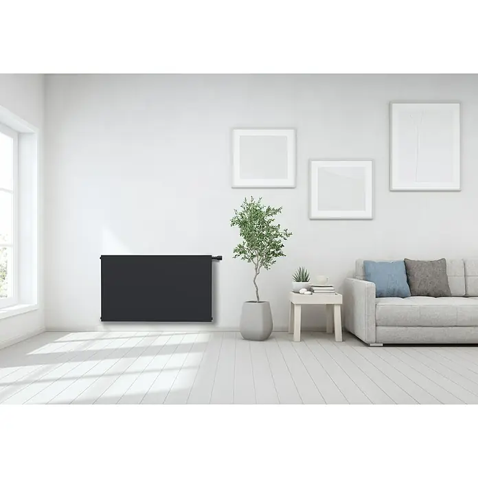 Sanicomfort PlanheizkörperB x H: 100 x 60 cm, Wärmeleistung bei Vorlauftemperatur von 75 °C (D: 50): 1.582 W, Typ Heizkörper: 22 - Schwarzer Heizkörper an weißer Wand in einem hellen Raum mit modernen Möbeln. Stilvolles Design für angenehme Wärme.