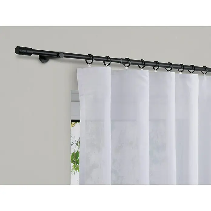 Expo Ambiente Stilgarnitur Rillcube - Länge Gardinenstange: 210 cm - 400 cm, Schwarz - Eine Nahaufnahme einer schwarzen Gardinenstange mit weißen, lichtdurchlässigen Vorhängen, die an Ringen befestigt sind, vor einer hellgrauen Wand.