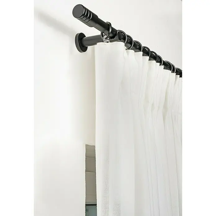 Expo Ambiente Stilgarnitur Rillcube - Länge Gardinenstange: 210 cm - 400 cm, Schwarz - Nahaufnahme einer schwarzen Gardinenstange mit weißen Vorhängen, die elegant an einer weißen Wand befestigt ist.