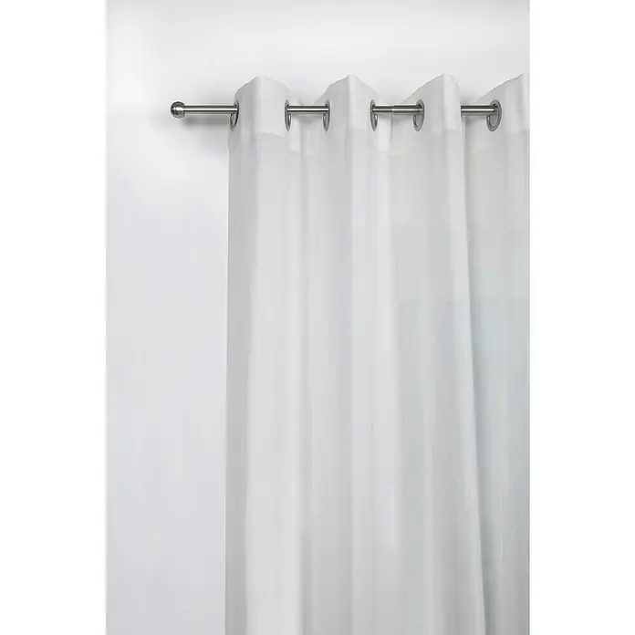 Expo Ambiente Stilgarnitur Habito-Rillball - Länge Gardinenstange: 210 cm - 400 cm, Edelstahloptik - Ein eleganter, weißer Vorhang mit Metallösen hängt an einer silbernen Gardinenstange und sorgt für eine helle und luftige Atmosphäre.