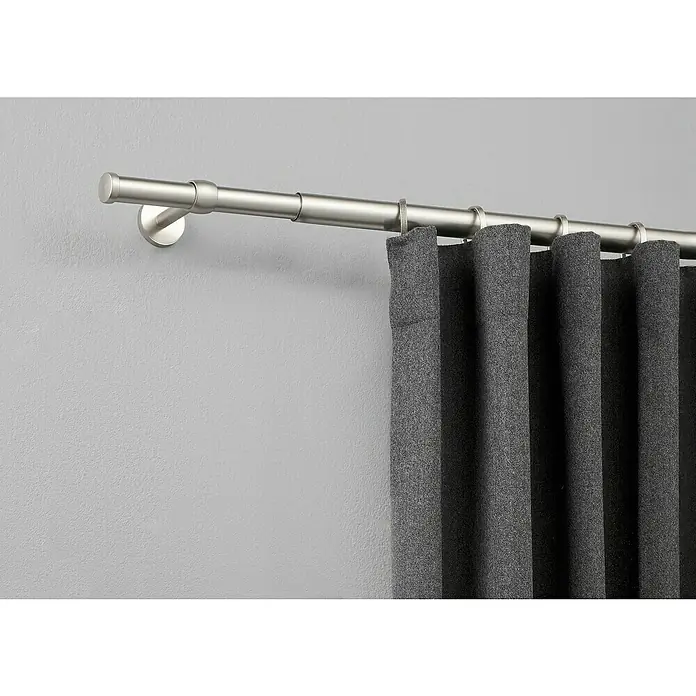 Expo Ambiente Stilgarnitur Cap-Noble - Edelstahloptik, Länge Gardinenstange: 120 cm - 210 cm - Detailaufnahme einer grauen Gardine an einer silberfarbenen Gardinenstange, die an einer grauen Wand befestigt ist.
