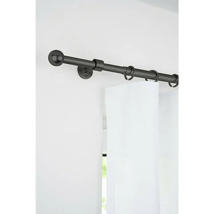 Komplettgarnitur 2in1 - Schwarz, 120 cm - 210 cm, Metall, Ausziehbar - Nahaufnahme einer schwarzen Vorhangstange mit Kugelende, Ringen und weißem Vorhang vor einer hellen Wand.