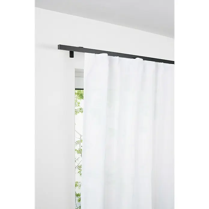 Komplettgarnitur All-in - Schwarz, Länge Gardinenstange: 160 cm - 280 cm - Das Bild zeigt eine Gardinenstange mit weißen Vorhängen vor einem Fenster, die eine minimalistische und elegante Fensterdekoration darstellen.