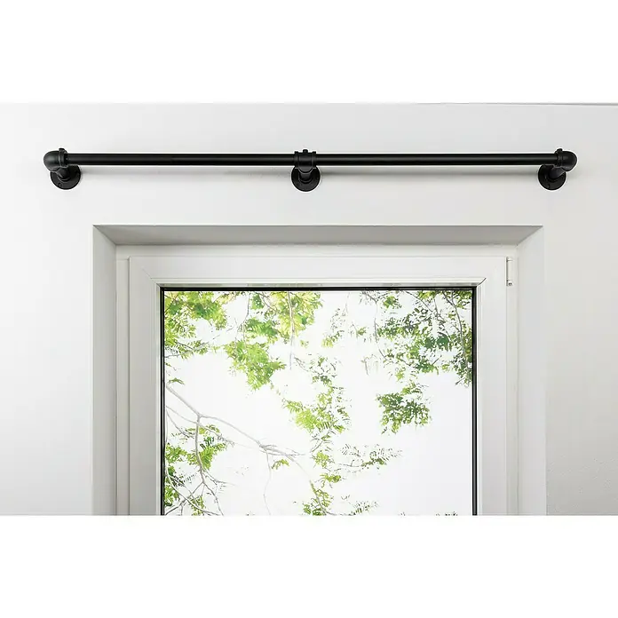 Stilgarnitur Industrial - Schwarz, Länge Gardinenstange: 160 cm - 280 cm - Eine schwarze, industrielle Gardinenstange aus Metallrohr, die über einem Fenster mit Blick auf grüne Bäume angebracht ist.