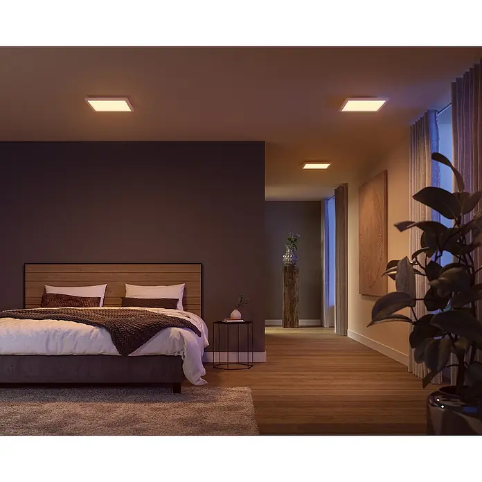 Philips Hue LED-Panel White & Color Ambiance Surimu - Classic - 24,8 W, L x B x H: 30 x 30 x 4,6 cm, Weiß, Opal, RGBW - Ein modernes Schlafzimmer mit quadratischen LED-Deckenleuchten, die eine warme und einladende Atmosphäre schaffen.