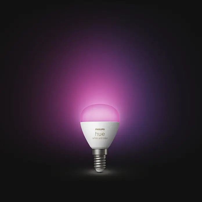 Philips Hue Smart-LED-Lampen Set White & Color Ambiance Tropfen - E14, Dimmbar, RGBW, 470 lm, 5,1 W, 1 Stk. - Nahaufnahme einer Philips Hue White and Color Glühbirne, die in einem leuchtenden Pinkton erstrahlt und smarte Beleuchtungslösungen präsentiert.