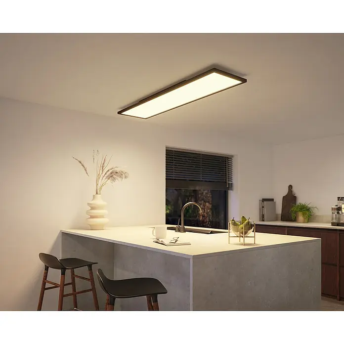 Philips Hue LED-Panel Aurelle39 W, L x B x H: 120 x 30 x 4,6 cm, Schwarz, Warmweiß - Bild einer rechteckigen Deckenleuchte, die eine moderne Kücheninsel beleuchtet, mit stilvollem Design und angenehmer Atmosphäre.