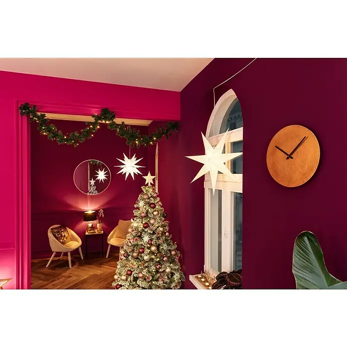 Rahmenspiegel Levi - Durchmesser: 80 cm, Gold, Metall - Festlich geschmückter Raum mit einem beleuchteten Weihnachtsbaum, Papiersternen und einer Girlande über der Tür. Goldene Wanduhr an burgunderroter Wand.