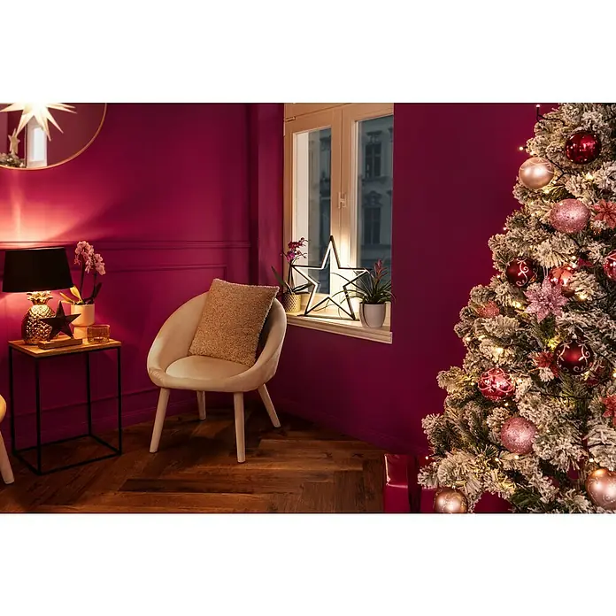 Kissen Teddy - Braun, 45 x 45 cm, 100 % Polyester - Festlich dekoriertes Wohnzimmer mit einem geschmückten Weihnachtsbaum, einem Sessel und einer Fensterdekoration mit Sternenlicht.