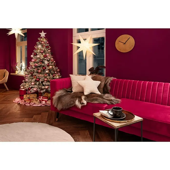 Kissen Teddy StarWeiß, 45 x 45 cm, 100 % Polyester - Festliches Wohnzimmer mit pinkem Samtsofa, Weihnachtsbaum und Sternenleuchten für eine gemütliche Atmosphäre.
