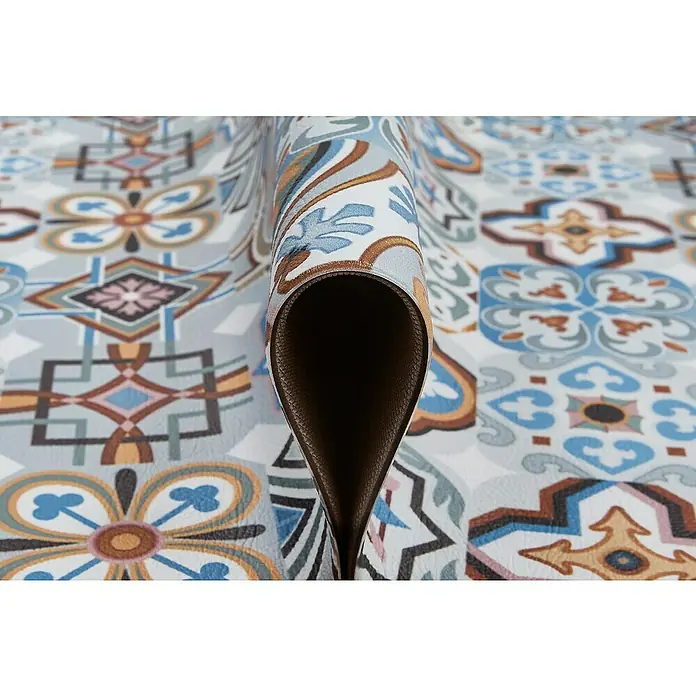 Teppichläufer MarrakeschBlau, 150 x 50 cm, 100 % Polyvinylchlorid - Nahaufnahme einer gemusterten, gerollten Vinyl-Bodenmatte. Das Dekor besteht aus einem Vintage-Fliesenmuster mit Braun-, Blau- und Grautönen.