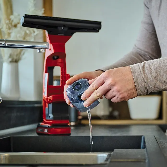 Einhell PXC 18V Limpiadora de cristales de batería Brillianto - 18 V, Sin batería, Volumen de recipiente: 0,1 l - El aspirador de ventanas inalámbrico Einhell se está llenando de agua, listo para una limpieza sin rayas. El diseño rojo destaca.