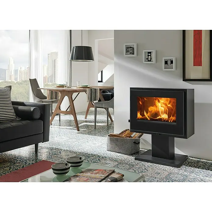 Panadero Kaminofen VERNE - 6,7 kW, Raumheizvermögen: 170 m³, Material Verkleidung: Stahl, Schwarz Metallic - Wohnzimmer mit einem modernen Kaminofen, der Wärme und Gemütlichkeit ausstrahlt, umgeben von stilvollen Möbeln und Dekorationen.