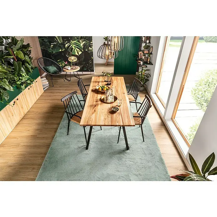 Teakschale - 37 x 29 x 8 cm, Teak - Helles Esszimmer mit großem Holztisch auf einem blaugrünen Teppich, umgeben von Stühlen und viel Grün, das eine natürliche und gemütliche Atmosphäre schafft.