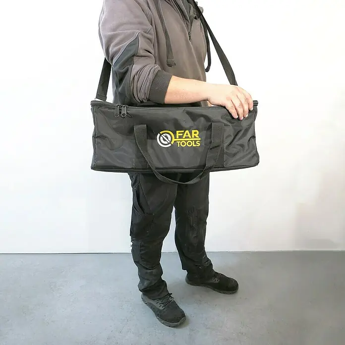 Fartools Werkzeugtasche MyRexbag - L x B x H: 530 x 230 x 200 mm, Passend für: Fartools Multischleifer REX 120C, Polyester - Die schwarze Werkzeugtasche "FAR TOOLS" wird von einer Person mit einem Tragegurt über der Schulter gehalten. Sie hat kurze Tragegriffe und ist mit einem Reißverschluss versehen.