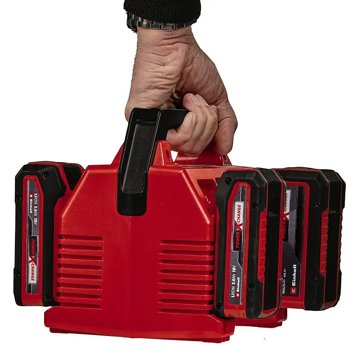 Einhell Power X-Change 18V Schnellladegerät Quattrocharger 4A - Passend für: Einhell Power X-Change Akkus - Aufnahme des Einhell Power X-Change Akku-Mehrfachladegeräts mit 4 Einschüben und Tragegriff, gehalten von einer Hand.