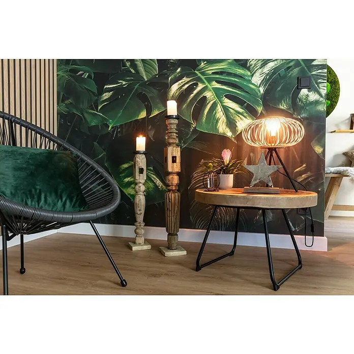 Komar Pure Fototapete Tropical Wall - 3 -tlg., B x H: 400 x 250 cm, Vlies - Stimmungsvolles Wohnzimmer mit einem Sessel, dekorativen Kerzenständern und einem Tisch mit Lampe, die eine warme Atmosphäre erzeugen.