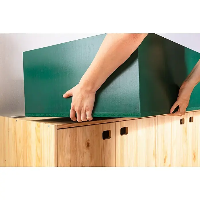 swingcolor Buntlack Acryl - Moosgrün, Seidenmatt, 375 ml, Wasserbasiert - Eine Person platziert eine grüne Holzkiste auf einem Holzschrank. Die Kiste ist groß und rechteckig, der Schrank ist aus hellem Holz.