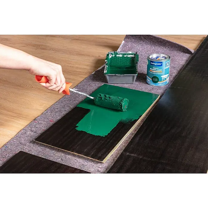 swingcolor Lackier-Set - 3 -tlg. - Ein Farbtablett, eine Dose Swingcolor Acryl Buntlack und eine Person, die Farbe mit einer Farbwalze auf ein Holzbrett aufträgt.