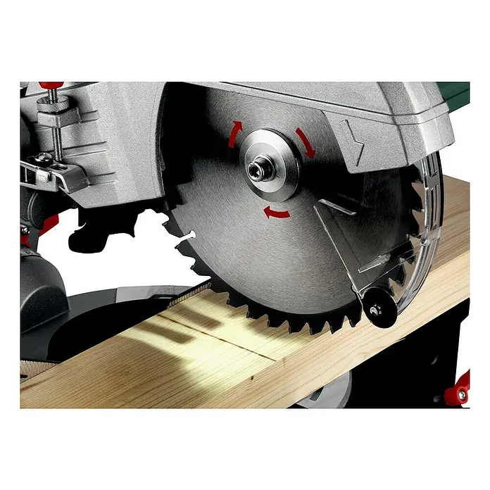 Metabo Kapp- & Gehrungssäge KGS 305 M - 1.600 W, Durchmesser Sägeblatt: 305 mm, Leerlaufdrehzahl: 3.700 U/min - Eine Nahaufnahme einer Kreissäge beim Schneiden eines Holzstücks mit roten Pfeilen, die die Drehrichtung anzeigen.