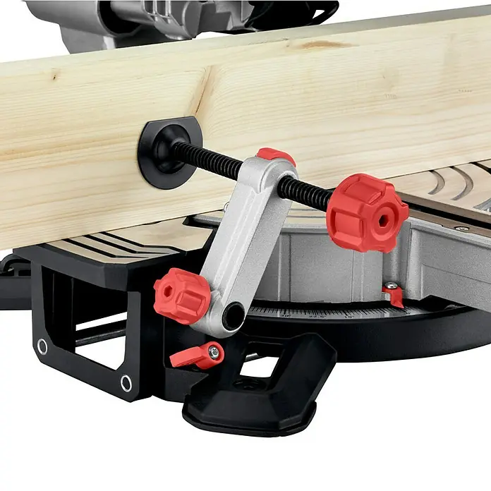 Metabo Kapp- & Gehrungssäge KGS 216 M Set - 1.500 W, Durchmesser Sägeblatt: 216 mm, Leerlaufdrehzahl: 5.000 U/min - Eine Nahaufnahme einer Kapp- und Gehrungssäge mit einer Holzplatte, die mit einer Schraubzwinge befestigt ist, um präzise Schnitte zu gewährleisten.
